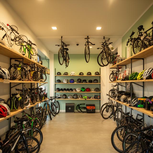 Interior de loja de bicicletas em Seixal com acessórios pendurados, prateleiras e piso amplo